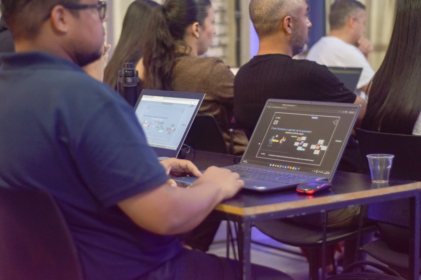 Notebooks abertos exibem o módulo 'Como Humanos e agentes de IA aprendem', ponto de partida da Metodologia IA PhD.